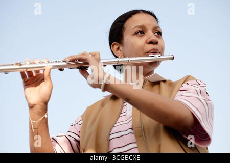 Young Adult Woman Playing Flute Outdoors during Daytime Stock Photo