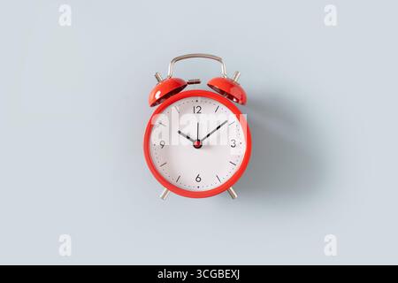 Red alarm clock on blue background. View from above. Stock Photo