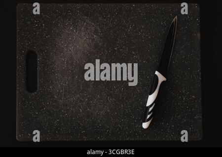 Old worn plastic cutting board with knife marks, highlighting potential microplastic contamination. Top view. Stock Photo