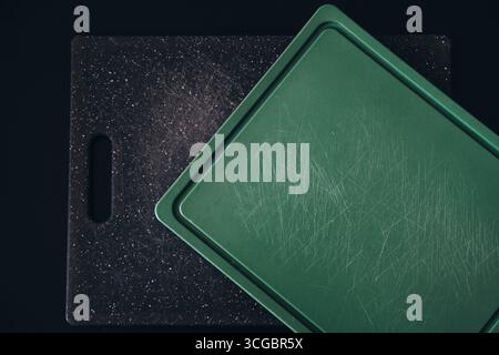 Worn plastic cutting boards with knife marks, highlighting potential microplastic contamination. Top view. Stock Photo
