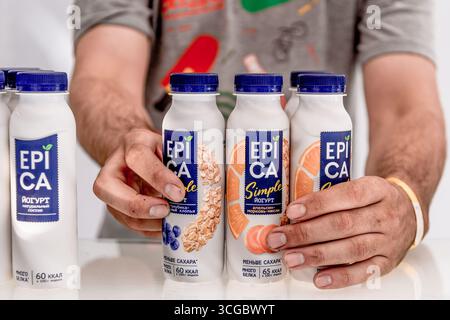 Moscow, Russia, 7 July 2019, Worker exhibits plastic bottles of Epica yogurt on the store counter Stock Photo