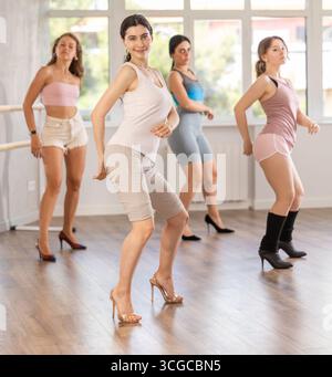 Slim brunette in heels practicing jazz-funk dance in studio Stock Photo