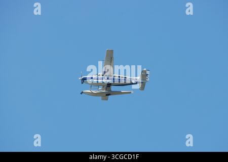 a seaplane in the air against a clear blue sky by the company Blade, a new york commuter and tourism air travel company, copy space Stock Photo