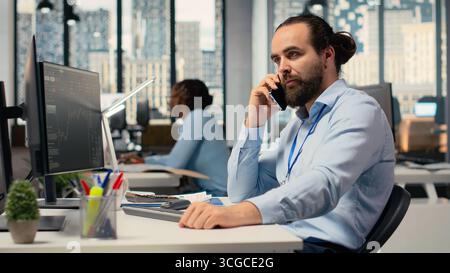 Financial advisor offers investment guidance during call with clients using smartphone. Investment consultant doing mobile phone call, helping customers build tailored portfolio Stock Photo