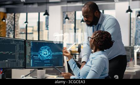 Prop firm staff members using artificial intelligence tech to ensure smooth trading operations. Team of traders in office using AI chatbot to analyze stock market portfolio positions Stock Photo