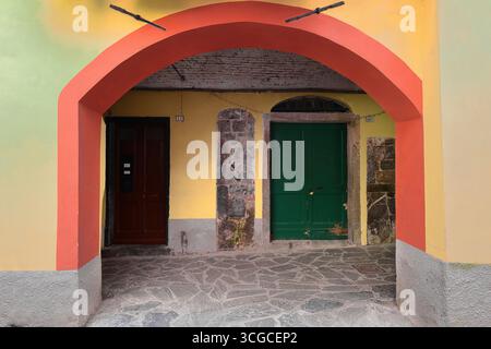 257 Yellow facade with an orange segmental arch of the arcade running along Via Buranco Street south side, in the old town. Monterosso al Mare-Liguria Stock Photo