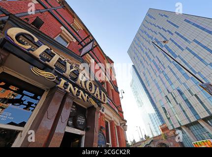 Exterior of the City Road Inn in Manchester city centre, with the modern glass tower of the Hilton Manchester Deansgate rising in the background Stock Photo
