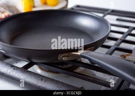 A view of a non-stick skillet pan on a stove top in a kitchen setting. Stock Photo