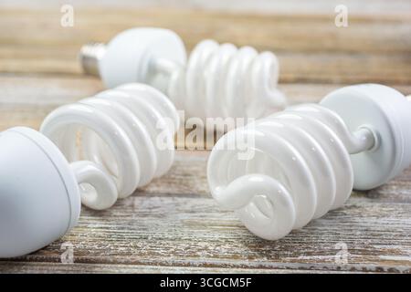A view of three CFL light bulbs on a wooden surface. Stock Photo