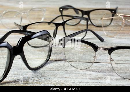 A view of several retro eyeglasses on a wooden table. Stock Photo