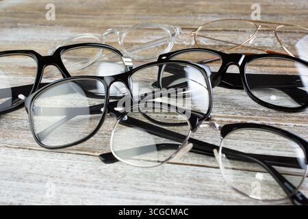A view of several retro eyeglasses on a wooden table. Stock Photo