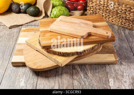 A view of a stack of several wooden cutting boards and cheese serving boards, in a still life setting. Stock Photo