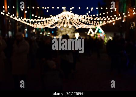 Blurry defocused decoration bokeh lights at Christmas market at night with copy space Stock Photo