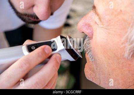 A close-up view of a hand holding an electric trimmer. Canosa DP, Puglia. Italy Stock Photo