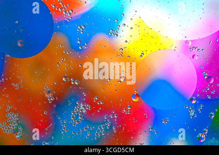 Oil on water abstract.  Colourful and bright, a creative abstract photograph image of oil bubbles floating on water with a multi-coloured background. Stock Photo