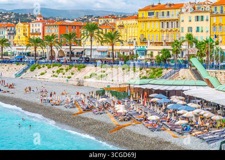 Tourists enjoy the Castel Plage private beach club and restaurant on the shores of the Bay of Angels on the Riviera in Nice, France Stock Photo