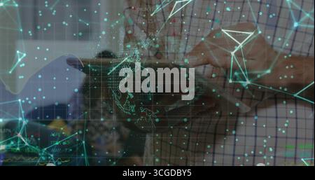 Mid adult man holding tablet computer and exploring holographic network in tech lab, with circuits Stock Photo