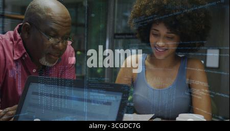 Collaborating mentor and mentee reviewing code at glass meeting room, with laptop and coffee cup Stock Photo