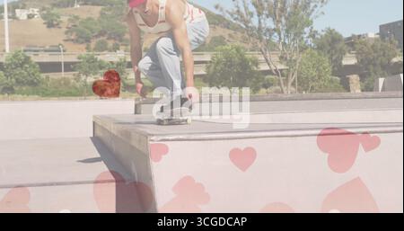 Crouching skater in red baseball cap descending concrete ramp on skateboard at skate park Stock Photo