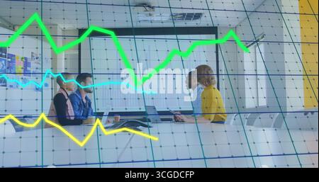 Collaborating four business professionals analyzing digital graphs in conference room, with laptops Stock Photo