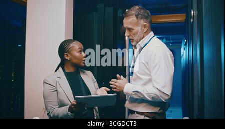 Tablet, team and people in data center for discussion, cloud computing or IT training with intern. Collaboration, tech or engineer in server room for Stock Photo