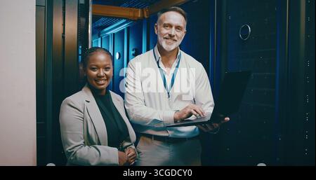 Portrait, laptop and people in server room, programming and cooperation with engineering. IT specialist, system solution and employees with tech, data Stock Photo