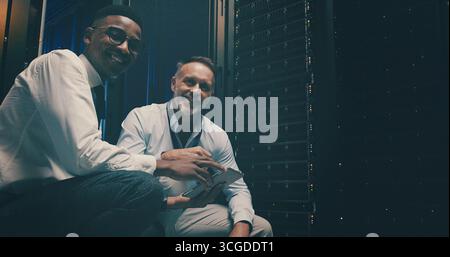 Portrait, team and men with tablet, server room or confident for network engineering or programming. Happy, IT specialist and people with tech for Stock Photo