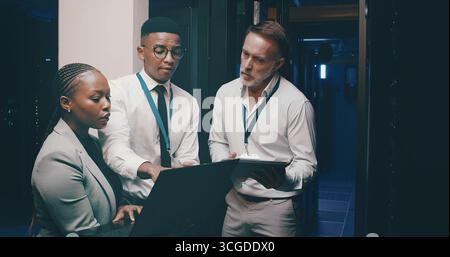 Talking, network and people with tech in server room for cybersecurity, diagnostics and IT support. Team, meeting and workers on laptop, tablet and Stock Photo