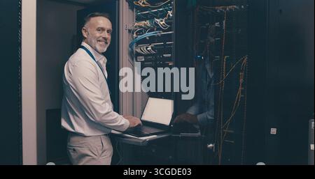 Laptop, portrait and network with man in server room for data center, technician or systems. Cybersecurity, software database and cloud computing with Stock Photo