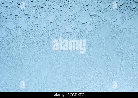 Water drops on glass in blue color temperature Stock Photo
