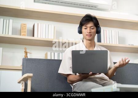 Remote Work. Young man participating in online meeting with laptop. Stock Photo