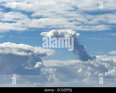 Cumulonimbus cluster cloud towering in the centre of the image, Altostratus above, Stratocumuus below, international Stock Photo