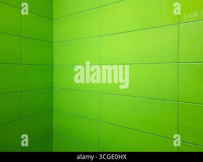 Shiny rectangular green tiles covering bathroom wall. Creating clean lines and modern aesthetic. Ideal for backgrounds and design projects related to Stock Photo