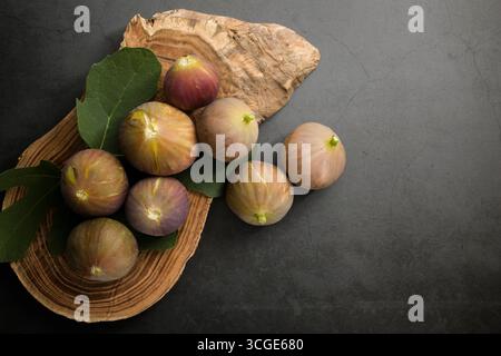 Fresh figs placed on top of wooden cutting board. Stock Photo