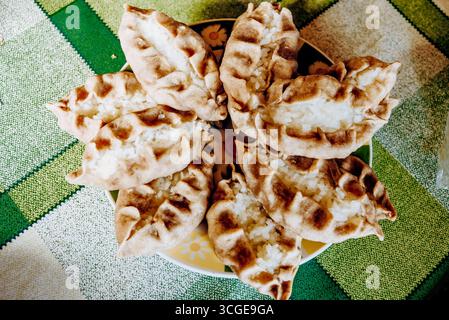 Pastries bakery from flour, pies with rice and meat on plate in rustic restaurant cafe Stock Photo