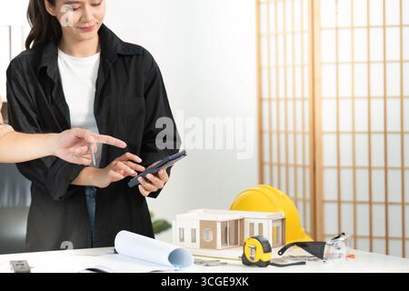 Digital Planning. Architect using smartphone to discuss construction project details. Stock Photo