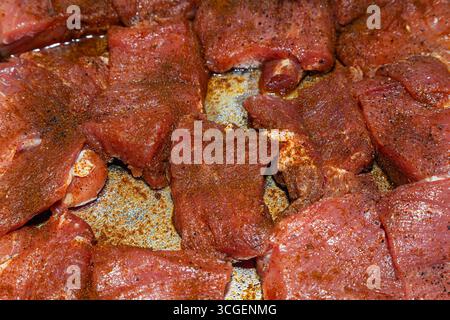 Pieces of juicy, fresh beef in spices, close-up. Beef raw steaks, top view. Stock Photo