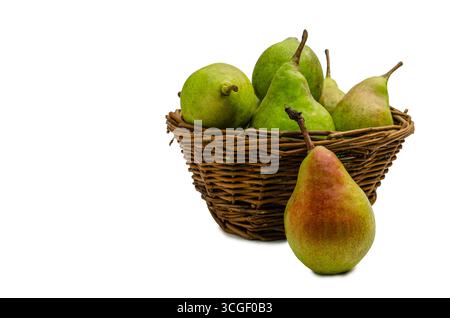 A vibrant, close-up  shot of a single ripe pear with a hint of red, leaning against a rustic wicker basket overflowing with several other fresh green Stock Photo