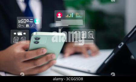 Businessman using smartphone and tablet with digital data analytics, online communication, and document management icons overlay, modern business tech Stock Photo
