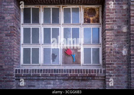 Dilapidated windows with tulip artwork to a house in Honfleur, Normandy France. Stock Photo