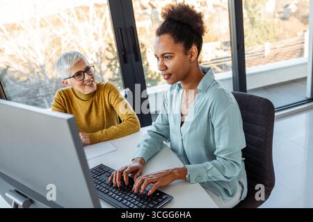 Mixed team of software engineers brainstorming ideas. Diverse app developers collaborating as group Stock Photo