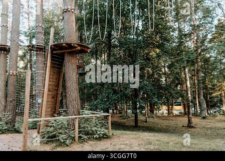 Empty playground with multi-colored play complex in pine forest, panorama on summer cloudy day Stock Photo