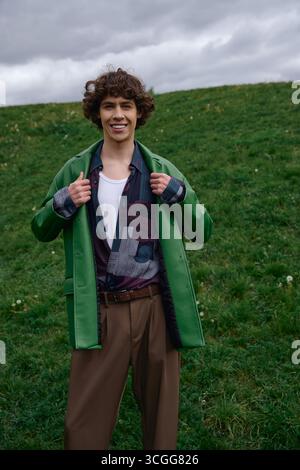 A joyful young man takes a relaxing walk outdoors, connecting with nature and simplicity. Stock Photo