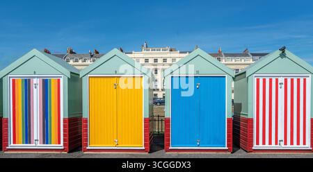 Colourful beach huts on Brighton seafront against a bright blue sky in August 2025. Stock Photo
