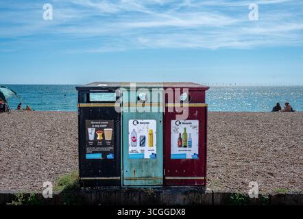 Three recycling bins along Brighton seafront placed on the pebble beach. Stock Photo