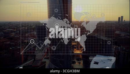 Displaying cylindrical skyscraper glowing in sunset glow at urban skyline, with world map overlay Stock Photo