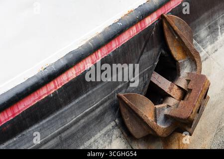 Large rusty metal anchor on a river ship. Stock Photo