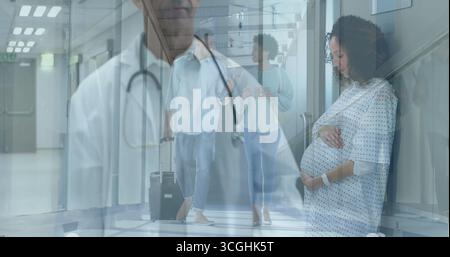 Sitting pregnant patient in hospital gown cradling belly on hospital bench, copy space Stock Photo