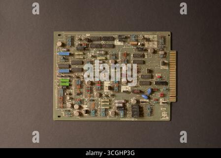 Detailed view of an old electronic circuit board with microchips, resistors and capacitors. Retro computer hardware background. Stock Photo