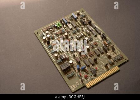 Close-up of a vintage electronic circuit board featuring resistors, capacitors, diodes and integrated circuits. Old technology background. Stock Photo